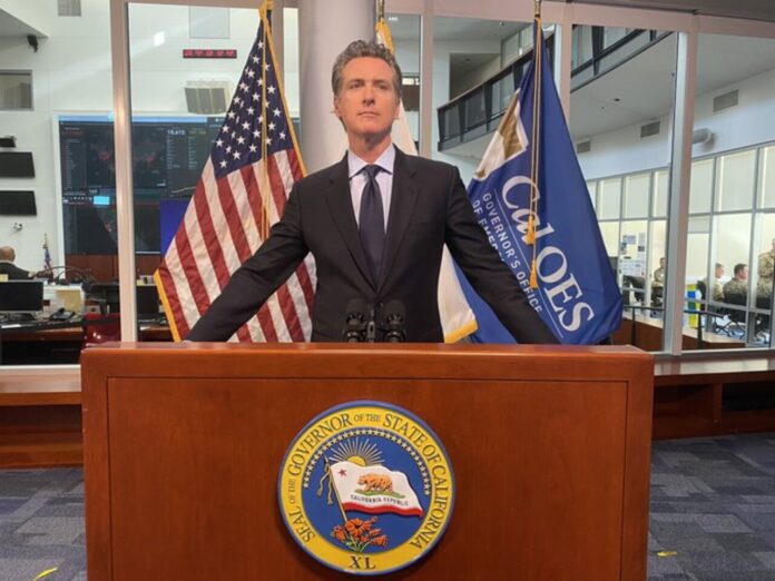 Gavin_Newsom_at_podium_before_a_press_conference_-_3.24.20 (1) Gavin_Newsom